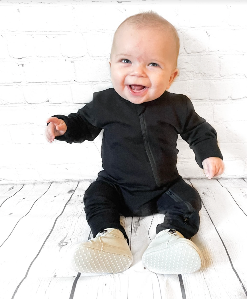 Smiling baby boy in two-way zip romper