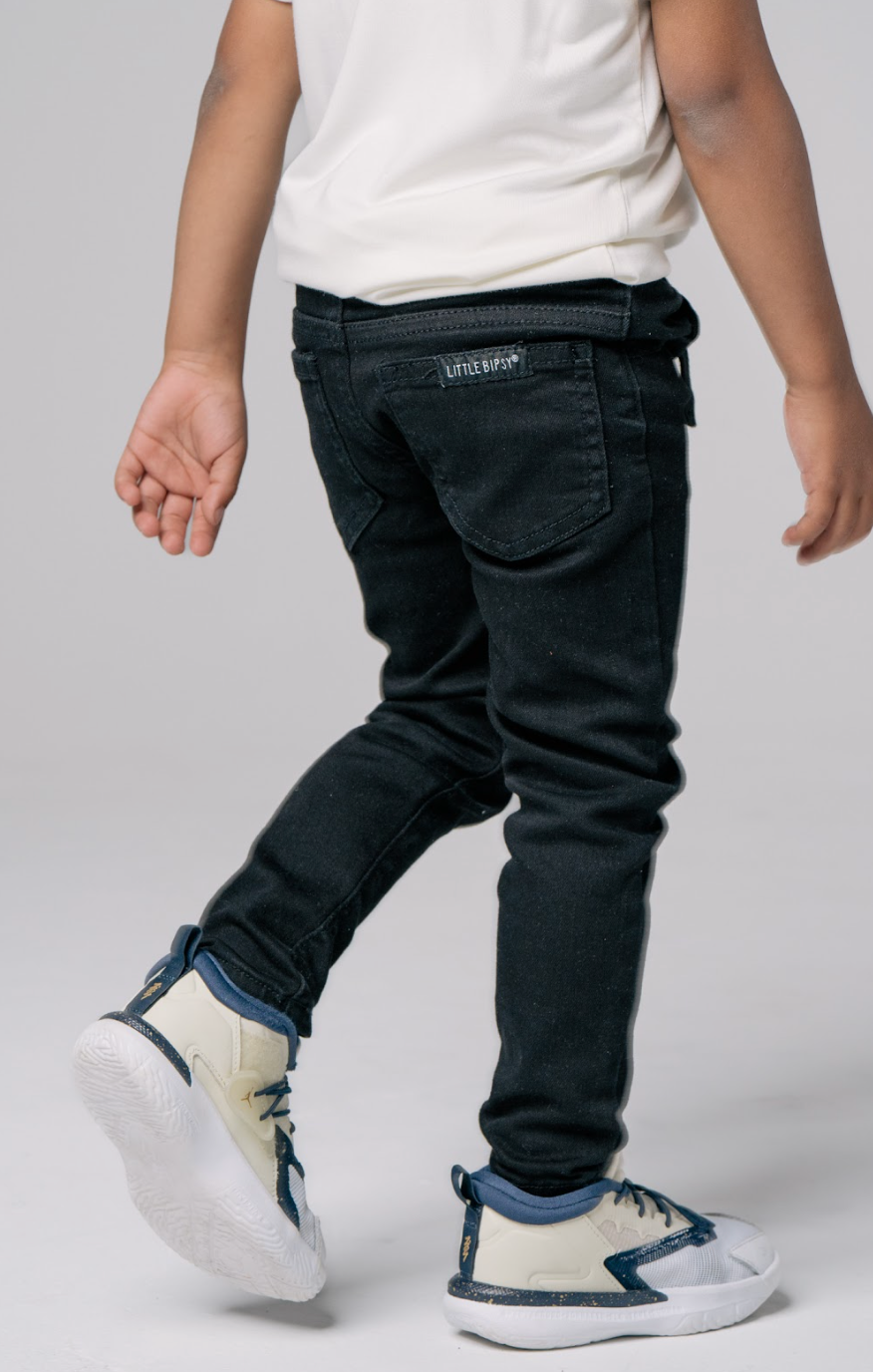 Trendy kids outfit. Kids black denim and kids sneakers.