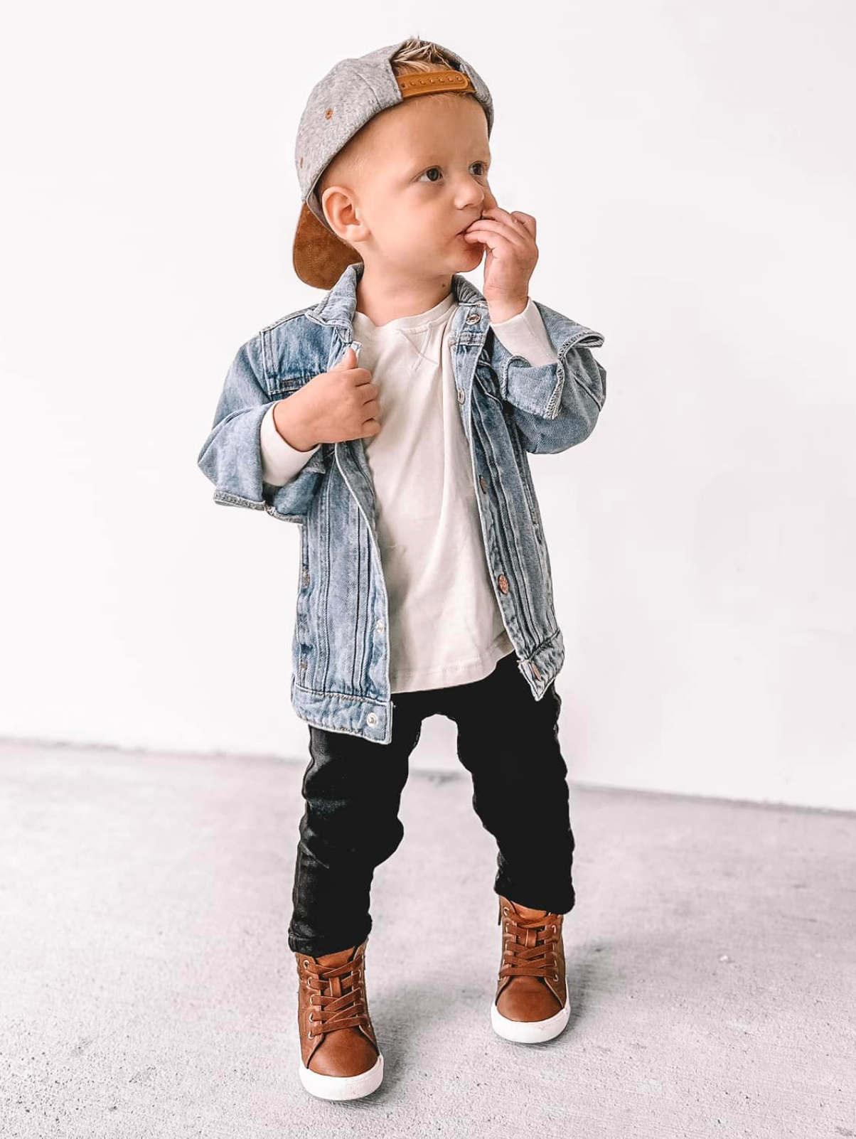 Toddler in trendy kids outfit. Kids denim jacket, kids basic long sleeve, and kids black denim. 