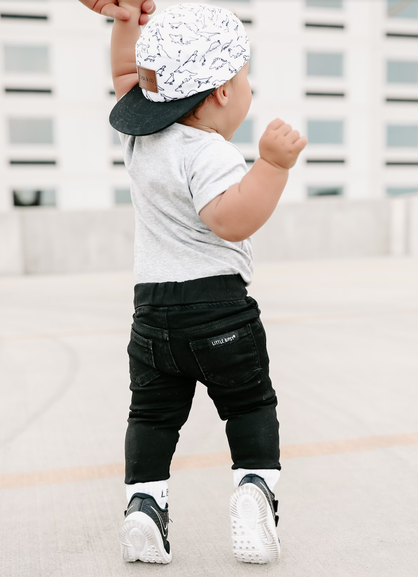 Baby in trendy kids outfit wearing baby jeans in black.